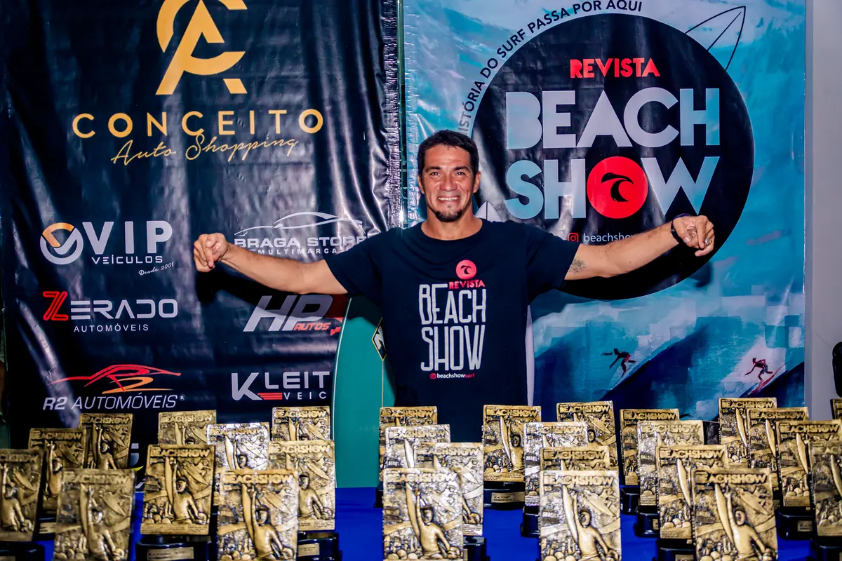 Anfitrião ao lado dos troféus do evento