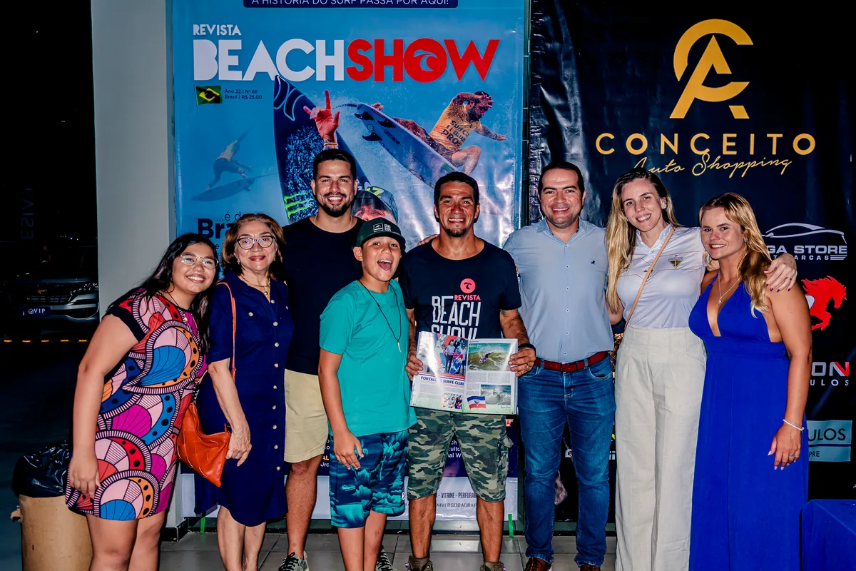 Convidados posando em frente ao painel da revista